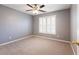 Comfortable bedroom with ceiling fan, plush carpet and large window with blinds at 1755 Presidents Dr, Lawrenceville, GA 30043