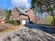 Side view of a brick home with a spacious driveway leading to a two-car garage at 1755 Presidents Dr, Lawrenceville, GA 30043