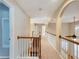 Carpeted upstairs hallway with arched doorways and wooden railings at 1755 Presidents Dr, Lawrenceville, GA 30043