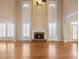 Spacious living room with hardwood floors, soaring ceilings, fireplace, and large windows at 1755 Presidents Dr, Lawrenceville, GA 30043
