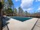 Large rectangular pool with a safety cover surrounded by a concrete deck and fenced perimeter, ensuring safety and privacy at 1755 Presidents Dr, Lawrenceville, GA 30043