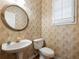 Half bath with pedestal sink, decorative mirror, and wallpaper at 1755 Presidents Dr, Lawrenceville, GA 30043