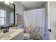 Bathroom with a floral shower curtain, vanity, sink, and a window that provides natural light at 5327 Saville Nw Dr, Acworth, GA 30101