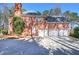 Brick home showcasing a three-car garage, well-maintained landscaping, and a serene setting at 5327 Saville Nw Dr, Acworth, GA 30101