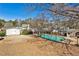 Fenced backyard featuring a pool, outbuildings, mature trees, and lush greenery at 6035 Wintergreen Rd, Norcross, GA 30093