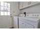 Convenient laundry room with white washer and dryer and access to the backyard at 6035 Wintergreen Rd, Norcross, GA 30093