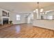 Bright living room with hardwood floors, a cozy fireplace, and an open view to the kitchen area at 6035 Wintergreen Rd, Norcross, GA 30093
