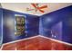 Bedroom features hardwood floors, blue paint, ceiling fan, and window with dark covering at 1377 Ling Dr, Austell, GA 30168