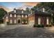 Elegant brick home showcasing manicured landscaping and a spacious circular driveway at dusk at 1446 W Wesley Nw Rd, Atlanta, GA 30327