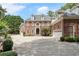 Grand brick home with circular driveway and well-manicured landscaping at 1446 W Wesley Nw Rd, Atlanta, GA 30327