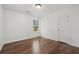 Cozy bedroom with wood-look flooring, a window with a view, and a white door at 165 Kentwood Springs Dr, Hampton, GA 30228