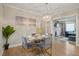 Bright dining area features a glass table, hardwood floors, a modern chandelier, and flows into an open-concept living space at 2132 Penrose Dr, East Point, GA 30344