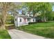 Cozy home with a red door, set in a lush green yard and a tranquil neighborhood at 2132 Penrose Dr, East Point, GA 30344