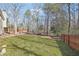 Expansive backyard featuring lush lawn and mature trees, providing a serene outdoor space at 509 Plantation Creek Dr, Loganville, GA 30052