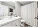 Bright bathroom with a white vanity, framed mirror and a shower with a patterned curtain at 509 Plantation Creek Dr, Loganville, GA 30052