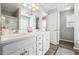 Bright bathroom featuring double sinks, white cabinetry, and wood-look flooring at 509 Plantation Creek Dr, Loganville, GA 30052
