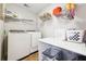 Well-organized laundry room with modern appliances, storage shelves, and folding table at 509 Plantation Creek Dr, Loganville, GA 30052