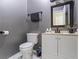 Powder room featuring a toilet, sink and cabinet with a framed mirror and grey paint at 3955 Pucketts Rd, Snellville, GA 30039