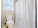 Bathroom featuring a white shower curtain, toilet, window and neutral paint at 3955 Pucketts Rd, Snellville, GA 30039