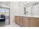 Bathroom featuring double sinks, hardwood cabinets, and a view to the exterior of the home at 3955 Pucketts Rd, Snellville, GA 30039