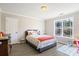 Cozy bedroom features wood-look flooring, a window, neutral paint, and a bed with striped bedding at 3955 Pucketts Rd, Snellville, GA 30039