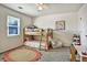 A bright bedroom with a bunk bed, colorful rug, window, and a ceiling fan at 5065 Timberbridge Ln, Johns Creek, GA 30022