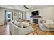 Comfortable living room featuring large windows, hardwood floors, and a fireplace at 5065 Timberbridge Ln, Johns Creek, GA 30022