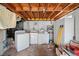 Basement area with a washer and dryer, white storage cabinet, and exposed ceiling beams at 853 Erin Sw Ave, Atlanta, GA 30310