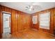 Bedroom with wood paneling, hardwood floors, a ceiling fan, and door to a side porch at 853 Erin Sw Ave, Atlanta, GA 30310