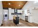 Open kitchen with white cabinets, stainless steel appliances, wood plank ceiling, and a mobile island at 8176 Camp St, Douglasville, GA 30134