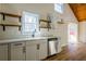 Charming kitchen with white cabinets, quartz countertops, stainless steel dishwasher, and open shelving at 8176 Camp St, Douglasville, GA 30134