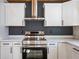 Well-appointed kitchen features white cabinets, stainless steel oven, and gray accent wall at 8176 Camp St, Douglasville, GA 30134
