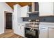 Kitchen featuring white cabinets, black hardware, stainless steel oven, and hardwood style floors at 8176 Camp St, Douglasville, GA 30134