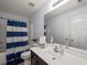 Cozy bathroom featuring blue and white shower curtain, white cabinets, and ample vanity space at 1227 Clear Stream Rdg, Auburn, GA 30011