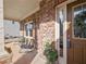 Inviting front porch with seating and a colorful flower pot, with brick siding and a brown front door at 1227 Clear Stream Rdg, Auburn, GA 30011