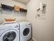 Bright laundry room with front-loading washer and dryer, overhead shelving for storage at 1227 Clear Stream Rdg, Auburn, GA 30011