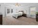 Bright main bedroom featuring tray ceiling, neutral paint, carpet flooring and several large windows at 1227 Clear Stream Rdg, Auburn, GA 30011