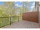 Private wooden balcony with a black metal railing and privacy screen, offering a view of the surrounding trees at 2327 Mason Dr # D23, Atlanta, GA 30316