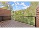 Exterior wooden balcony with black metal railing overlooking a lush green landscape under a blue sky at 2327 Mason Dr # D23, Atlanta, GA 30316