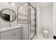 Modern bathroom with shower, grey-striped tiles, and circular mirror at 2327 Mason Dr # D23, Atlanta, GA 30316