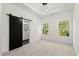 Bright bedroom with light carpet, white walls and a barn door to the bathroom at 2327 Mason Dr # D23, Atlanta, GA 30316