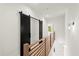 Hallway with hardwood floors, wooden railing and a black barn door, creating a modern and inviting entrance at 2327 Mason Dr # D23, Atlanta, GA 30316