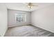 Spacious bedroom with plush carpeting, a ceiling fan, and a large window for natural light at 404 Ridgefield Dr, Peachtree City, GA 30269