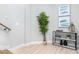 Hallway featuring light wood floors, an elegant plant, and a marble topped console table at 4834 Neal Rdg, Atlanta, GA 30349