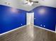 This bedroom features striking blue walls, luxury vinyl, and a ceiling fan at 5735 Hedge Brook Dr, Cumming, GA 30028