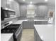 Modern kitchen with stainless steel appliances, gray cabinets, and an island at 5735 Hedge Brook Dr, Cumming, GA 30028