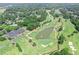 Overhead of lush golf course, a stream flowing into a pond, and the neighborhood clubhouse at 7015 Polo Dr, Cumming, GA 30040