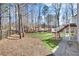 Well-maintained backyard featuring green grass, a black fence, and a wooden staircase to a raised porch at 7015 Polo Dr, Cumming, GA 30040