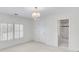 Bright bedroom featuring a chandelier, two windows with shutters, and an attached bathroom at 7015 Polo Dr, Cumming, GA 30040