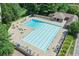 A stunning community pool surrounded by sun loungers, umbrellas, and lush greenery at 7015 Polo Dr, Cumming, GA 30040